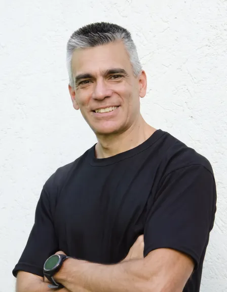 Portrait of Mg. Mauricio Moyano, smiling with his arms crossed