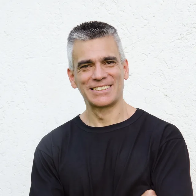 Portrait of Mg. Mauricio Moyano, smiling with his arms crossed